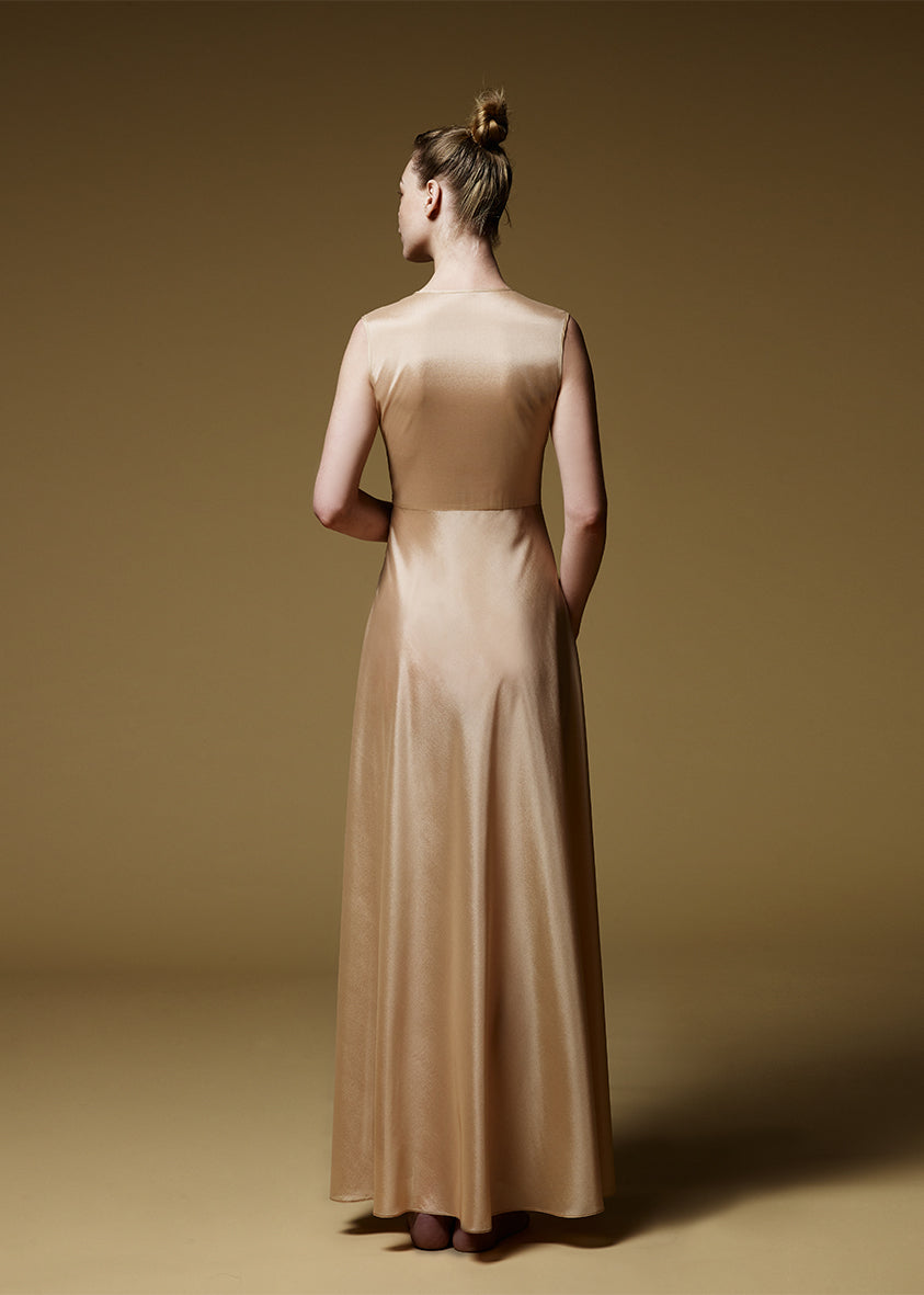 Jeune femme de dos habillée d'une robe longue beige en soie