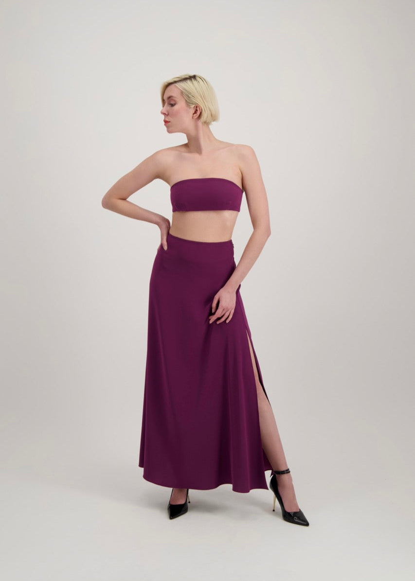 Femme blonde habillé d'un ensemble avec une jupe fendue et un bandeau lila