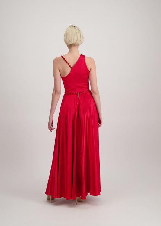 Jeune femme blonde de dos habillée d'une robe longue asymétrique rouge avec des détails bijoux réation SADEONE COUTURE