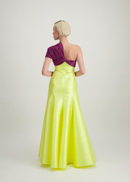 Jeune femme blonde de dos habillée d'une robe longue du soir asymétrique en violet et jaune