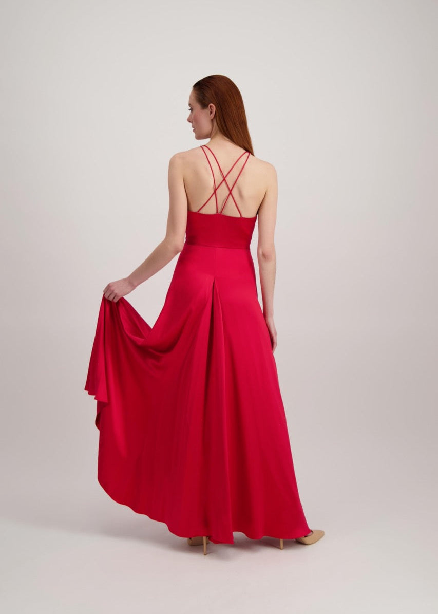Jeune femme rousse de dos habillée d'une longue robe rouge avec dos ouvert sur des bretelles croisées