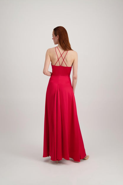 Jeune femme rousse de dos habillée d'une longue robe rouge avec dos ouvert sur des bretelles croisées