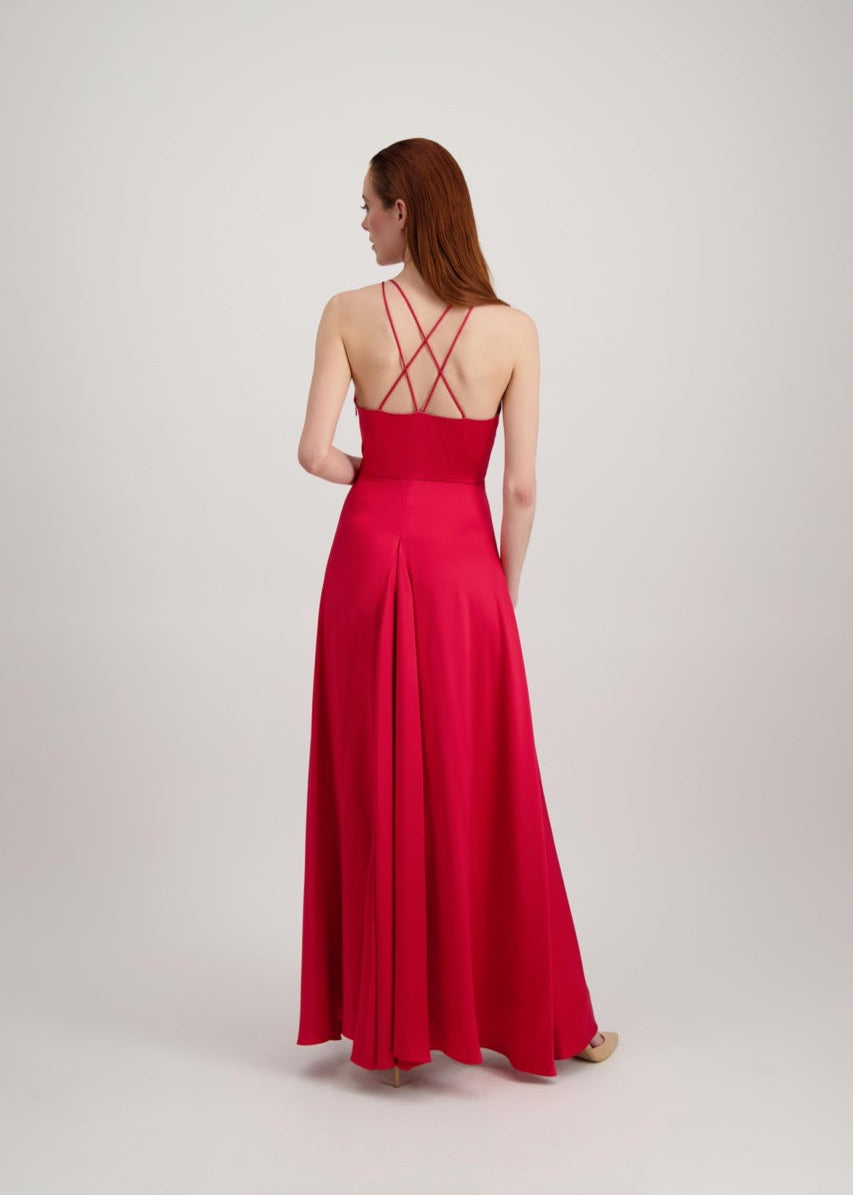 Jeune femme rousse de dos habillée d'une longue robe rouge avec dos ouvert sur des bretelles croisées