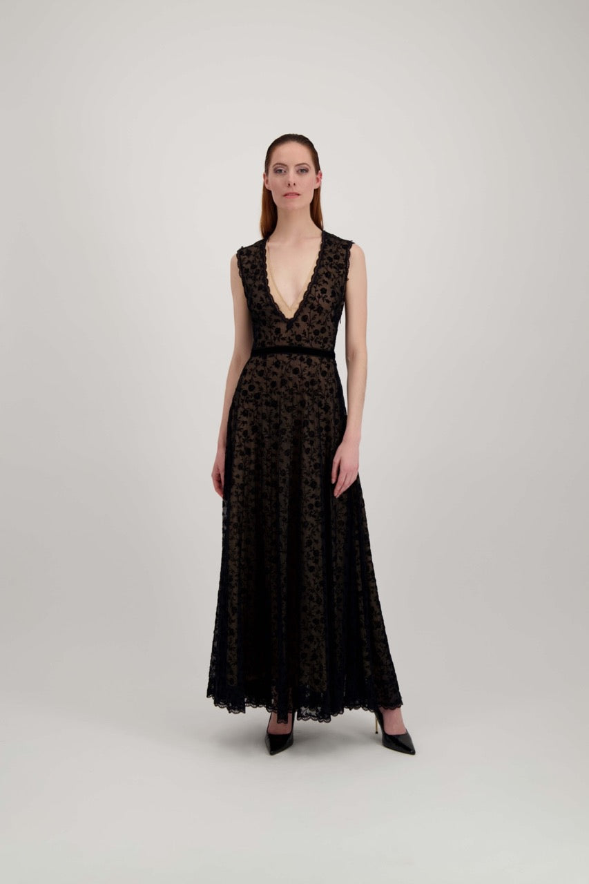 Jeune femme rousse habillée d'une longue robe du soir en tulle et velours noir avec un grand décolleté en V.