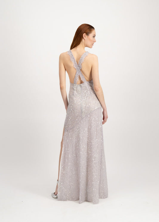 Jeune femme rousse habillée d'une longue robe du soir en dentelle brillante avec une grande fente