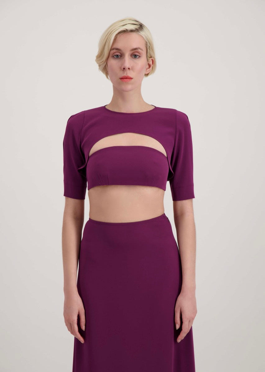Femme habillée d'un ensemble avec un boléro, un bandeau et une jupe lila