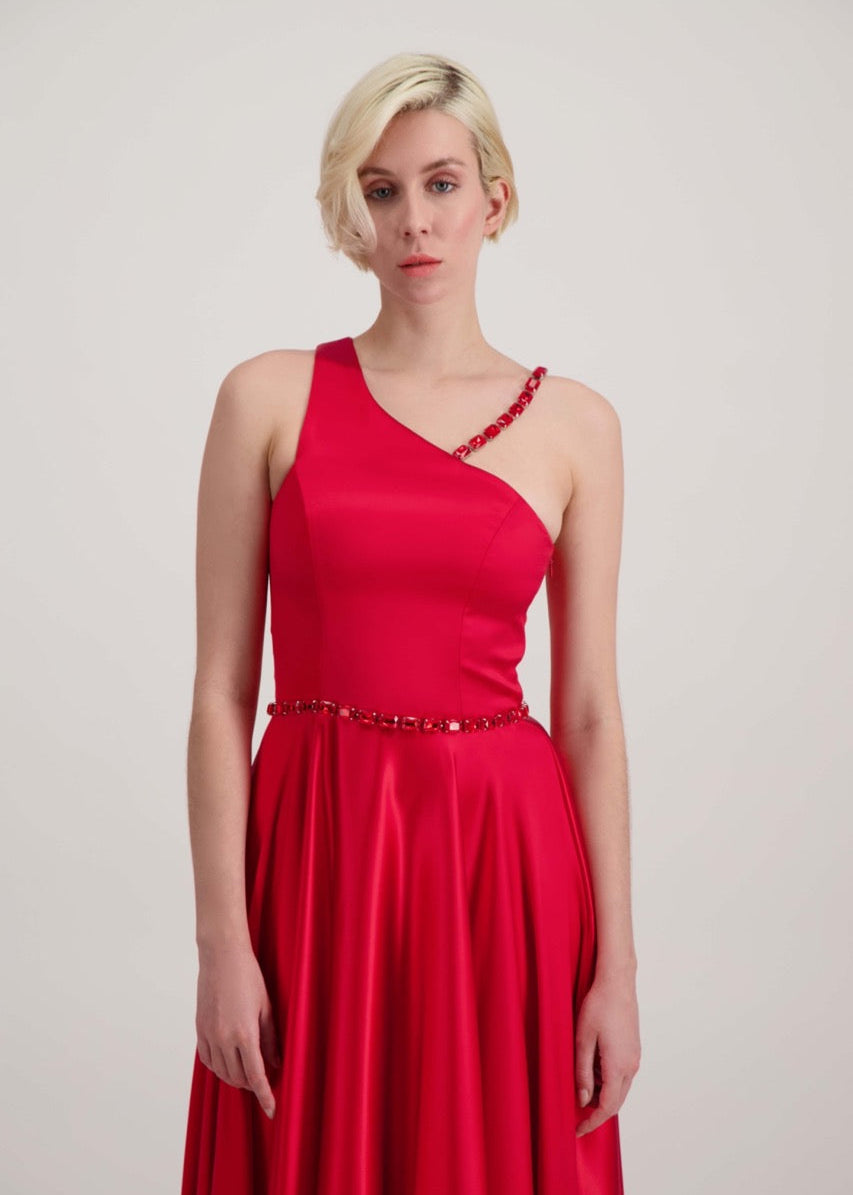 Jeune femme blonde habillée d'une robe longue asymétrique rouge avec des détails bijoux création SADEONE COUTURE