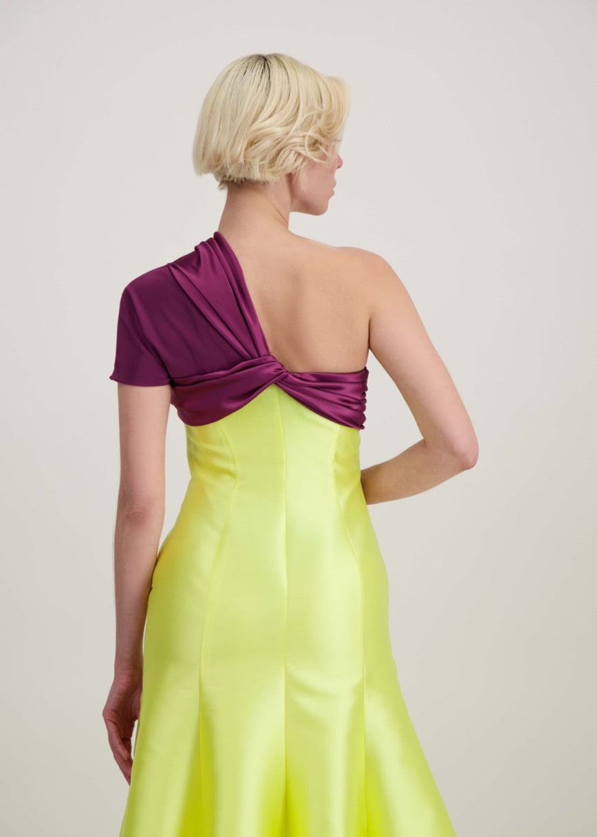 Jeune femme blonde de dos habillée d'une robe longue du soir asymétrique en violet et jaune