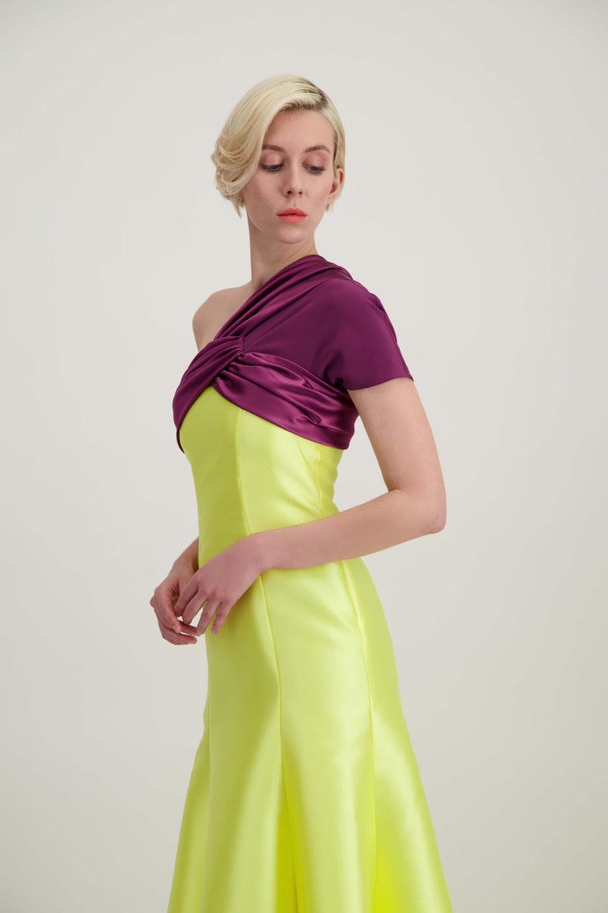 Jeune femme blonde de profil habillée d'une robe longue du soir asymétrique en violet et jaune