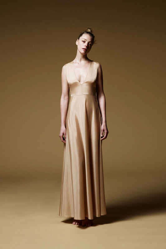 Jeune femme habillée d'un dessous de robe longue en soie beige