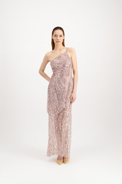Jeune femme rousse habillée d'une longue robe du soir rose et brillante avec une fente et portée par une seule bretelle