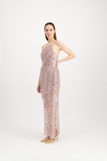 Jeune femme rousse habillée d'une longue robe du soir rose et brillante avec une fente et portée par une seule bretelle
