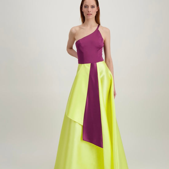 Jeune femme rousse qui marche habillée d'une longue robe du soir aux formes japonisantes de couleur violet et jaune