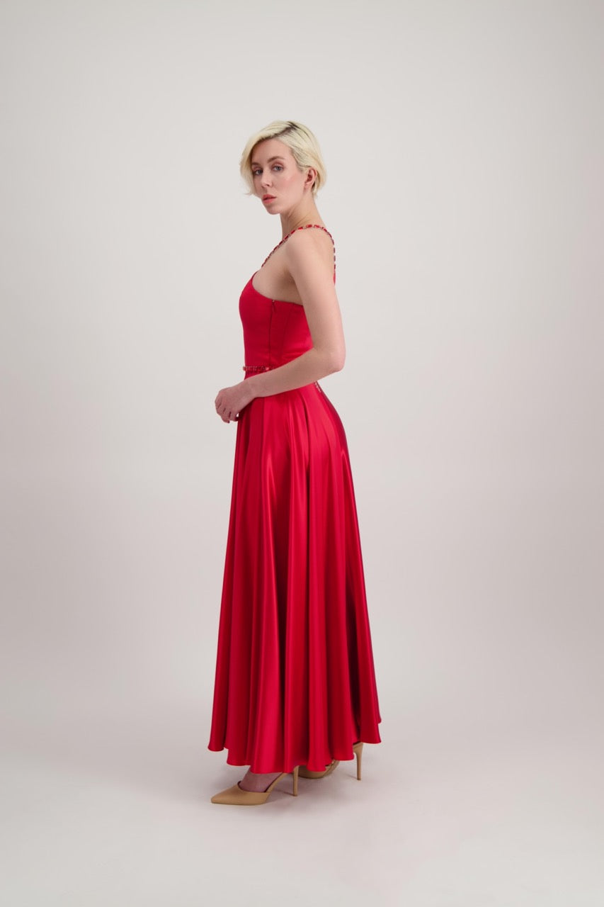 Jeune femme blonde qui tourne sur elle-même avec une longue robe du soir rouge qui tourne beaucoup