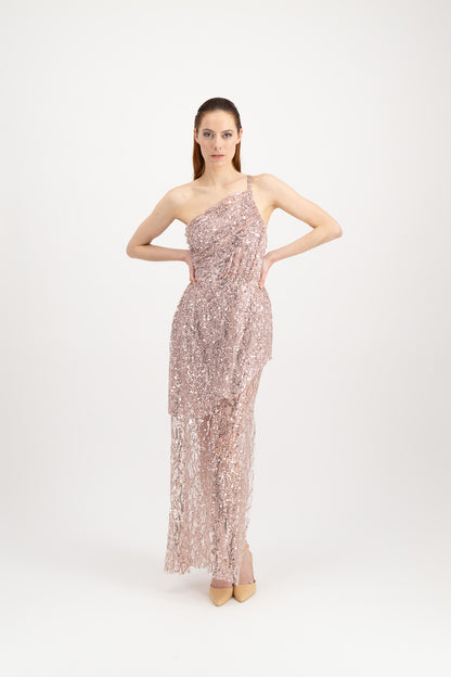Jeune femme rousse qui défile avec une longue robe du soir rose brillante asymétrique et avec une fente