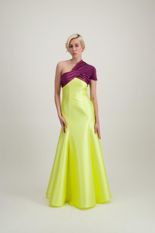Jeune femme blonde habillée d'une robe longue du soir asymétrique en violet et jaune