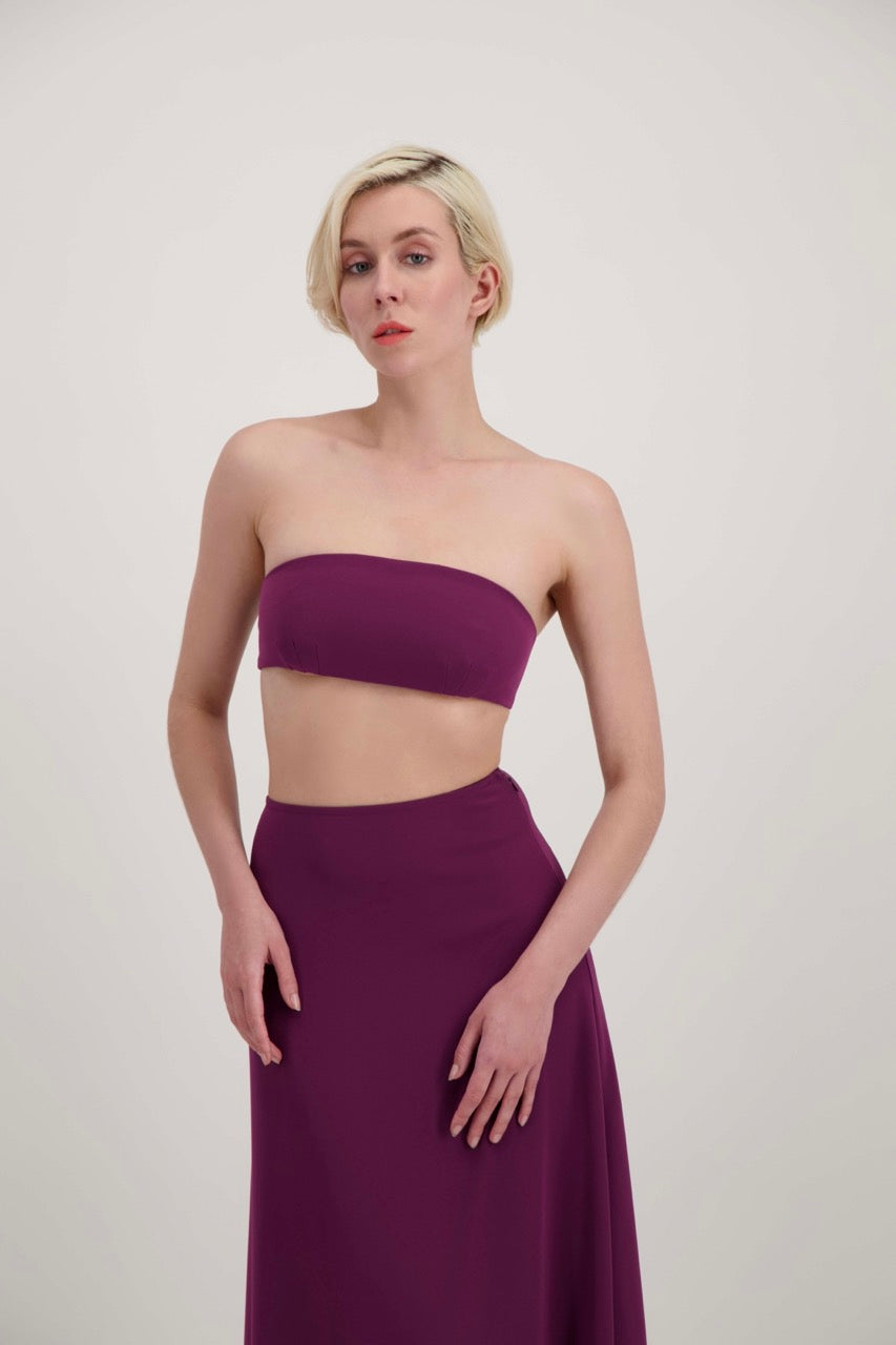 Femme blonde habillée d'un ensemble 2 pièces avec un bandeau et une jupe fendue lila