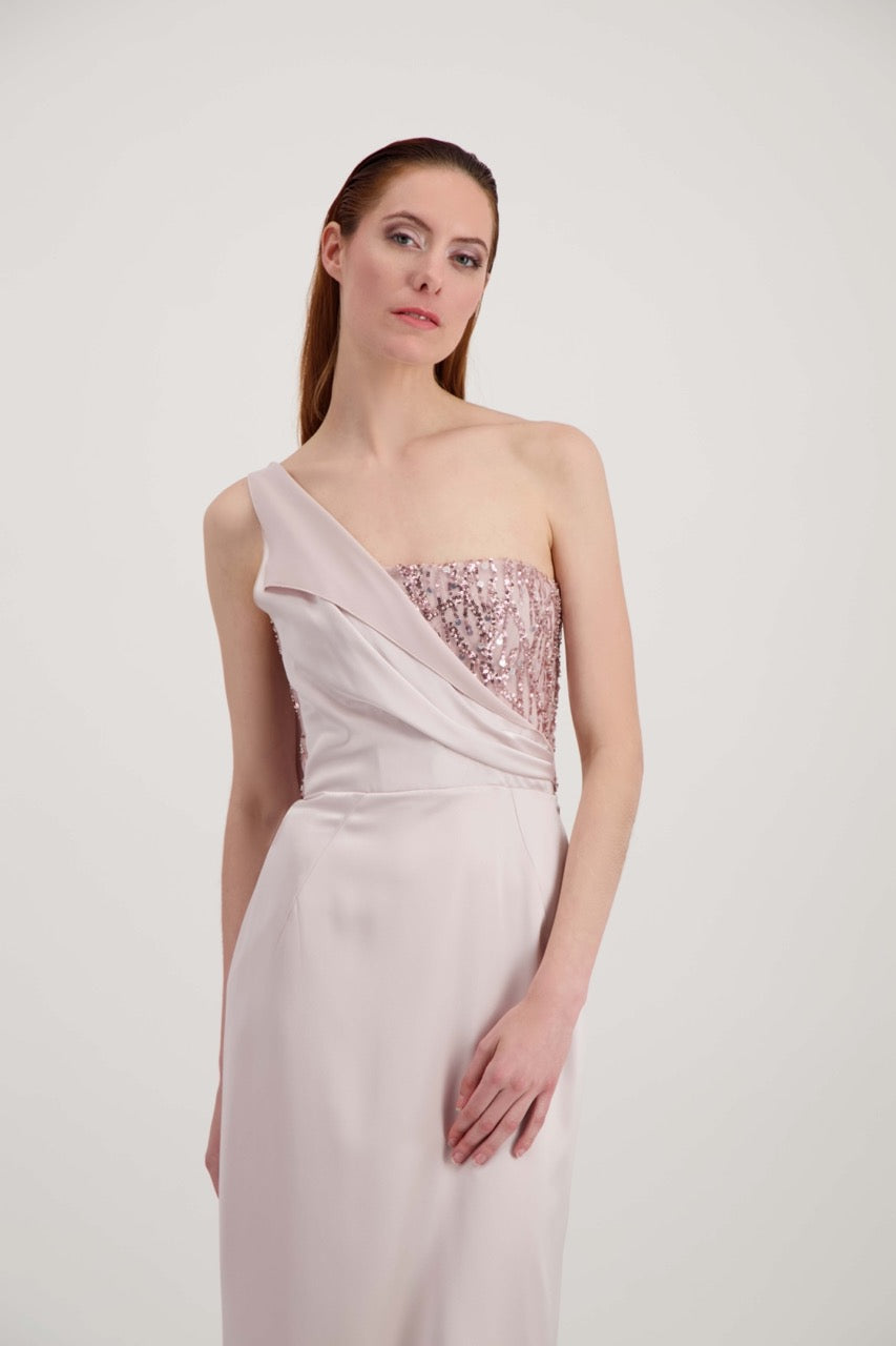 Jeune femme rousse habillée d'une longue robe rose avec un bustier pailleté